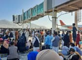 Afghans crowd the tarmac of Kabul airport on 16 August, 2021, trying to flee the country after the Taliban took control PIC: AFP via Getty Images