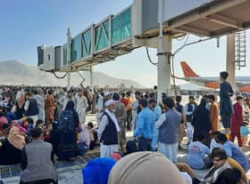 Afghans crowd the tarmac of Kabul airport on 16 August, 2021, trying to flee the country after the Taliban took control PIC: AFP via Getty Images