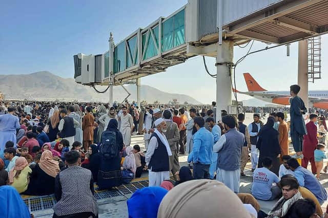 Afghans crowd the tarmac of Kabul airport on 16 August, 2021, trying to flee the country after the Taliban took control PIC: AFP via Getty Images