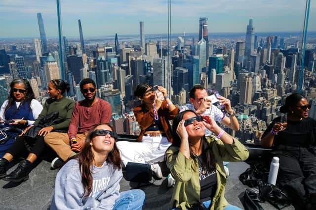 People look toward the sky at the 'Edge at Hudson Yards' observation deck ahead of a total solar eclipse across North America, in New York City. Photo by CHARLY TRIBALLEAU/AFP via Getty Images
