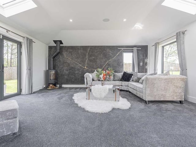 Lounge with unique feature wall and wood burning stove.