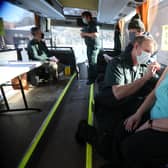 Paramedic Andrew Parker gives the vaccine to Elizabeth and Sandy Robertson inside a holiday coach outside Culloden Medical Practice near Inverness, Scotland, on 11 February - it is being used by the Scottish Ambulance Service as a mobile coronavirus vaccination centre picture: PA/Andrew Milligan