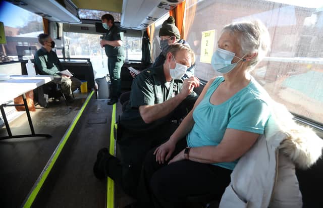Paramedic Andrew Parker gives the vaccine to Elizabeth and Sandy Robertson inside a holiday coach outside Culloden Medical Practice near Inverness, Scotland, on 11 February - it is being used by the Scottish Ambulance Service as a mobile coronavirus vaccination centre picture: PA/Andrew Milligan
