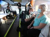 Paramedic Andrew Parker gives the vaccine to Elizabeth and Sandy Robertson inside a holiday coach outside Culloden Medical Practice near Inverness, Scotland, on 11 February - it is being used by the Scottish Ambulance Service as a mobile coronavirus vaccination centre picture: PA/Andrew Milligan