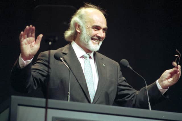 Sir Sean Connery acknowledges his audience's cheers before receiving the Freedom of the City of Edinburgh at the Usher Hall in 1991.
