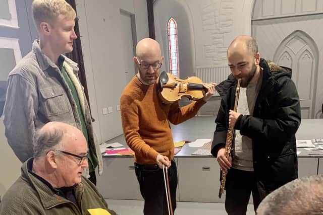 Jay Capperauld, violinist Gordon Bragg and flautist André Cebrián (all standing) with participants at a Seen and Heard session at Craigmillar Now