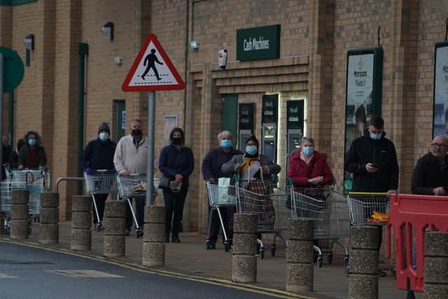People queue outside a Morrisons supermarket in Whitley Bay, Tyne and Wear.