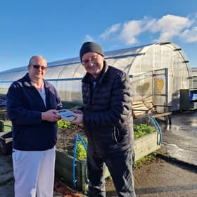 Ailean bho Taigh-Fuine MhicIlleathain a’ toirt diathad seachad do Dhòmhnall Dòmhnallach bho Tagsa Uibhist
