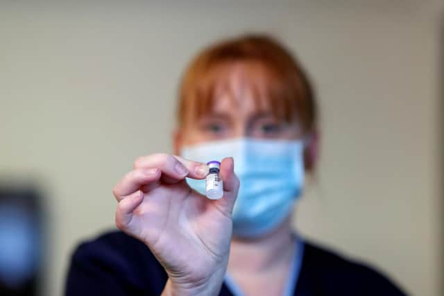 A member of the stuff holds the Pfizer/BioNTech COVID-19 vaccine at the Abercorn House Care Home in Hamilton.