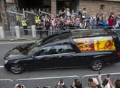 The hearse carrying the coffin of Queen Elizabeth II travels along the Royal Mile in Edinburgh to the Palace of Holyroodhouse as it completes it journey from Balmoral. Picture date: Sunday September 11, 2022.