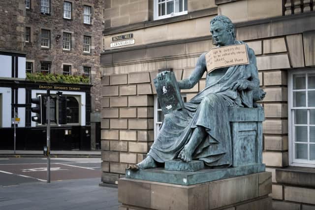 A sign hangs from the statue of the 18th-century philosopher David Hume on Edinburgh's Royal Mile with a racist quote from his essay Of National Characters (Picture: Jane Barlow/PA)