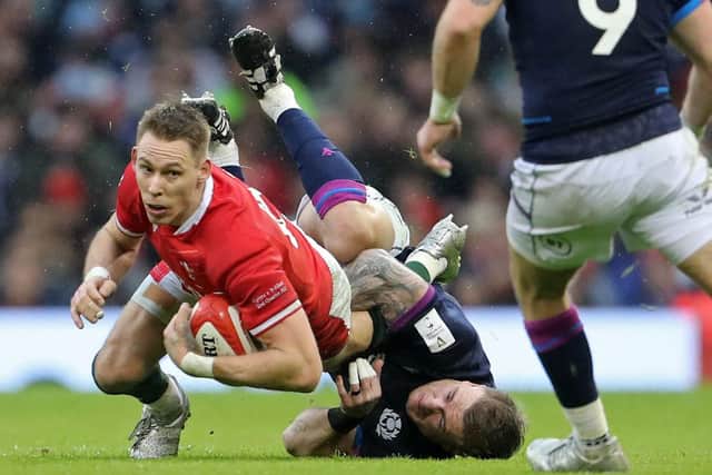 Wales' full-back Liam WIlliams (L) is tackled by Scotland's full-back Stuart Hogg  (Photo by GEOFF CADDICK/AFP via Getty Images)