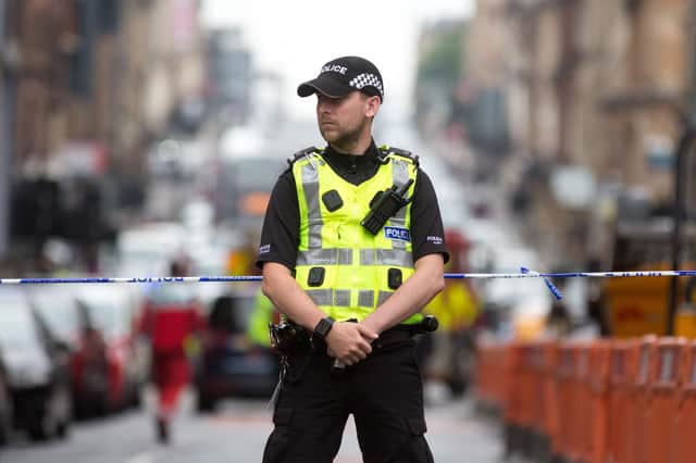 A police officer staffs a cordon as emergency services attend the scene of a fatal stabbing incident at the Park Inn Hotel in central Glasgow on June 26, 2020. - Scottish police on Friday said armed officers shot dead a man after a suspected stabbing in Glasgow left six others injured, including one of their colleagues.  The incident happened in and around a Park Inn hotel on West George Street, in the heart of the city. Several roads were closed and the surrounding area was cordoned off. (Photo by Robert Perry / AFP) (Photo by ROBERT PERRY/AFP via Getty Images)
