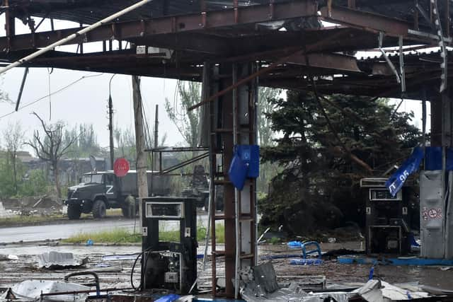 A Russian military truck painted with the letter Z is seen behind a destroyed petrol station in Ukraine's port city of Mariupol on May 18, 2022, amid the ongoing Russian military action in Ukraine. (Photo by Olga MALTSEVA / AFP) (Photo by OLGA MALTSEVA/AFP via Getty Images)