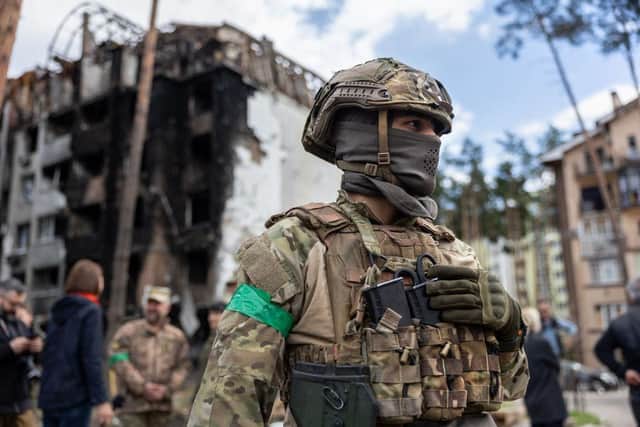 A Ukrainian army soldier stands guard at the war damaged Irpinsky Lipky residential complex in Irpin, Ukraine.