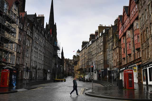 Members of the public walk through a deserted Edinburgh City Centre on Monday ahead of the national lockdown beginning