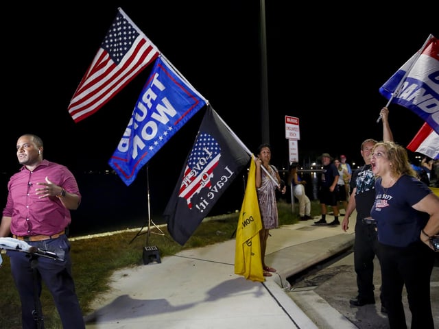 Supporters of former President Donald Trump shout as Kamrel Eppinger reports live for WPTV News Channel 5 near the home of former President Donald Trump at Mar-A-Lago on August 8, 2022 in Palm Beach, Florida. The FBI raided the home to retrieve classified White House documents.