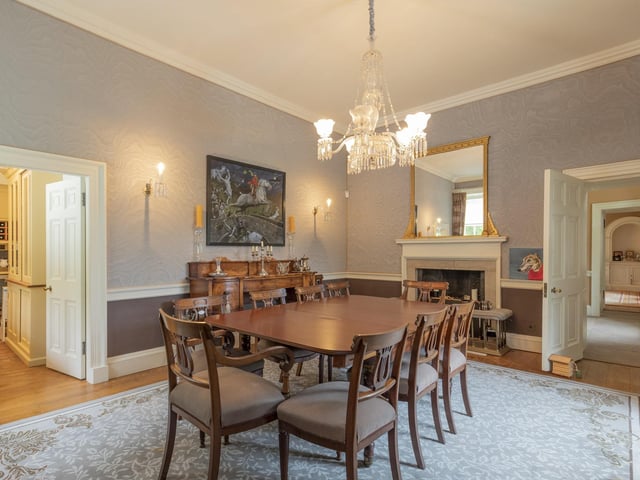 Interior: Grange House’s welcoming reception hall with flagstone floor has a grandiose spiral staircase leading to its nine public rooms, set over four storeys, including a large kitchen-dining room, conservatory, drawing room with beautiful fireplace, and ensuite master bedroom.