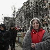 A woman walks beside a block of flats in Kyiv that was destroyed by shelling on Monday (Picture: Aris Messinis/AFP via Getty Images)