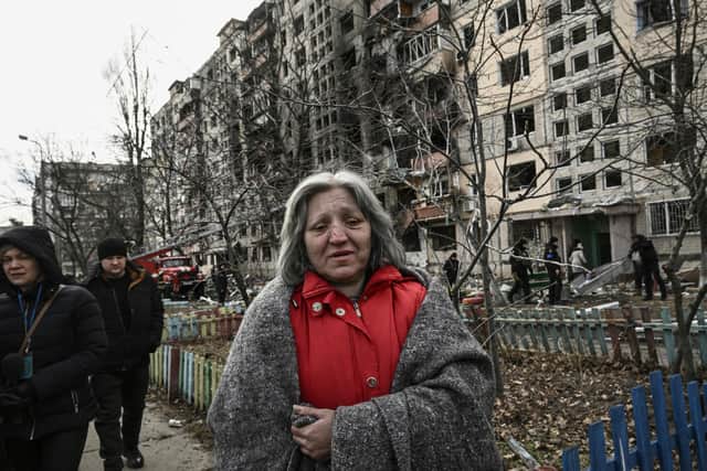A woman walks beside a block of flats in Kyiv that was destroyed by shelling on Monday (Picture: Aris Messinis/AFP via Getty Images)