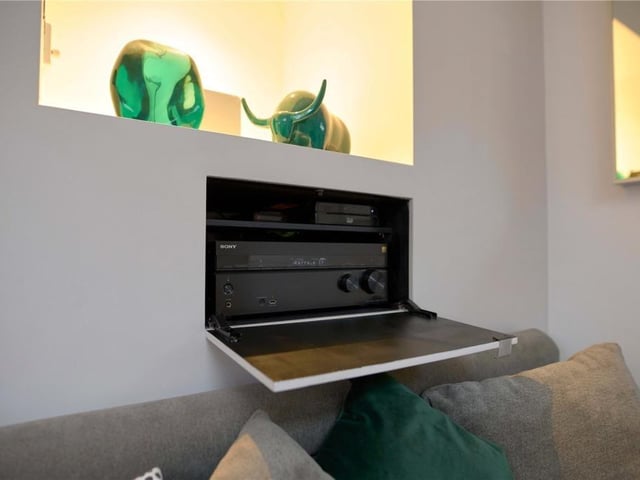 The living area includes an in-ceiling surround sound system installed throughout.