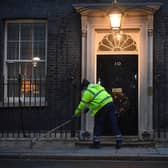 A man cleans the street in front of  10 Downing Street, London. The UK and European Union are on the threshold of striking a post-Brexit trade deal. An announcement is expected on Christmas Eve, but talks have continued through the night on the details of an agreement picture: Victoria Jones/PA Wire