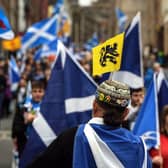 Pro-independence activists wave Scottish Saltire flags as they march from Holyrood to the Meadows in Edinburgh. Picture: Andy Buchanan/AFP via Getty Images
