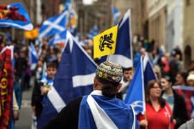 Pro-independence activists wave Scottish Saltire flags as they march from Holyrood to the Meadows in Edinburgh. Picture: Andy Buchanan/AFP via Getty Images
