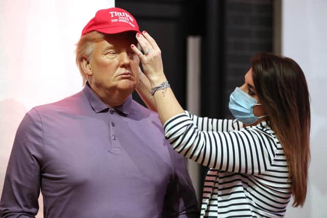 A member of staff at Madame Tussauds finishes dressing Donald Trump's waxwork in a new outfit following his defeat in the US presidential election. Picture: Jonathan Brady/PA