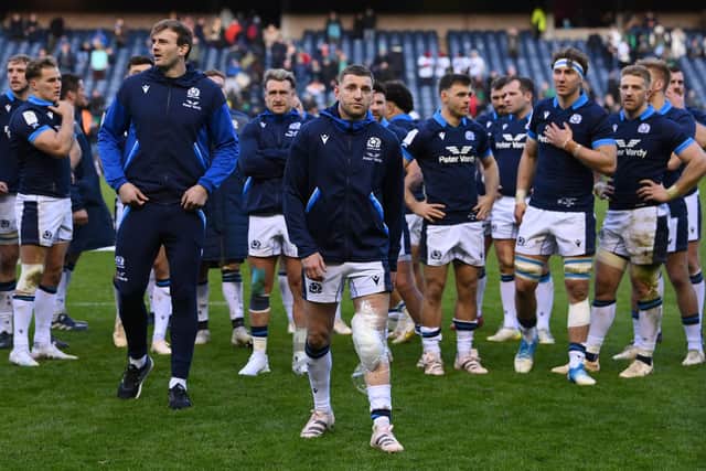 Finn Russell of Scotland looks dejected as players of Scotland leave the field.