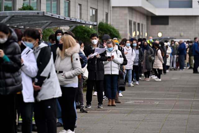 Members of the public queue for vaccinations on a vaccination bus at West College Scotland Clydebank Campus on December 17, 2021 in Glasgow, Scotland. (Photo by Jeff J Mitchell/Getty Images)