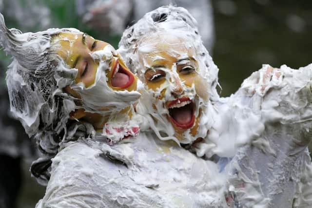 Two students covered in foam embrace post-foam fight. Picture: PA