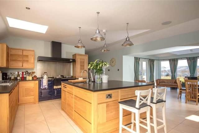 The spacious, open-plan kitchen has oak cabinetry and granite work surfaces with features such as a traditional Aga.