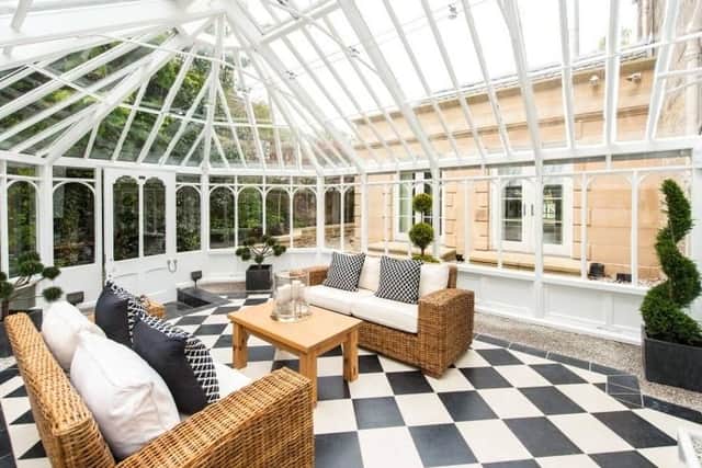 The conservatory features modern rattan furniture and an eye-catching floor.