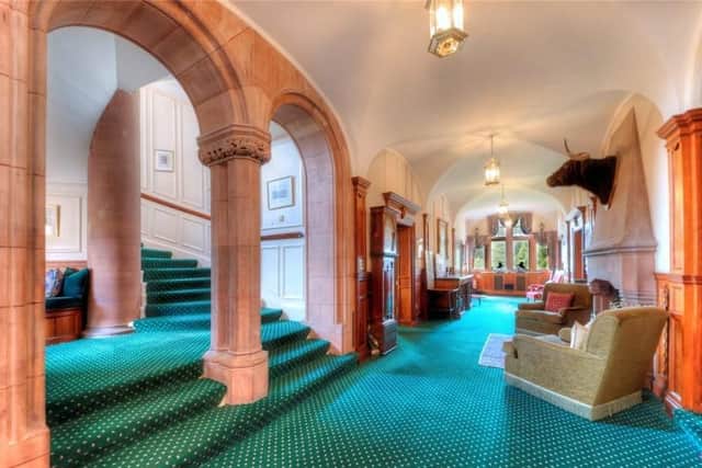 The hallway also has archways and a sweeping staircase to the upper floors.