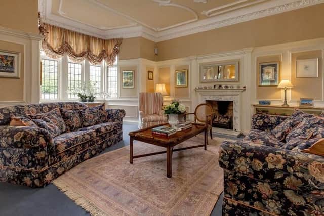 Th comfortable drawing room has a marble fireplace.