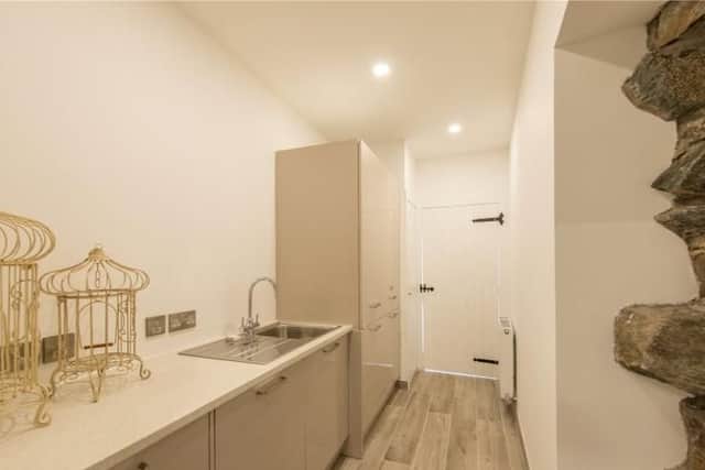 The modern utility room offers extra storage.