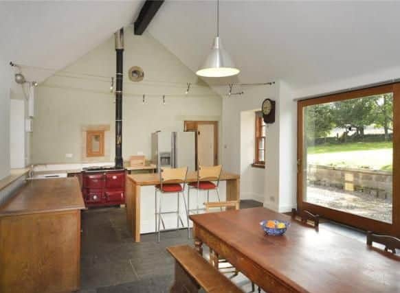 The dining kitchen has flagstone flooring and a wood-burning Rayburn which assists in the hot water production.