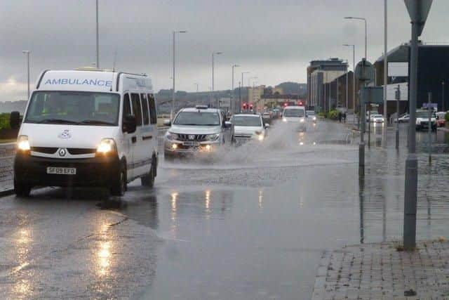 An ambulance navigates large puddles following the torrential rain in Fife.
