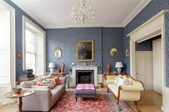 The living room has a traditional fireplace and cornicing.