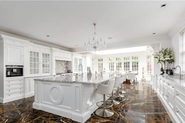 The vast kitchen has a huge island with dining space and well bespoke joinery work.