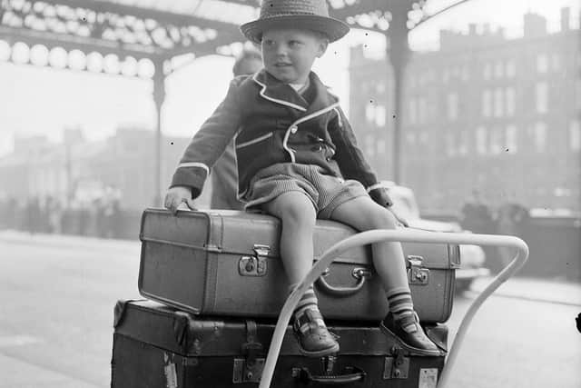 Three-year-old Paul Flannigan sits on top of the luggage ready to go on holiday at Glasgow Central Station in 1957. (Picture: TSPL)
