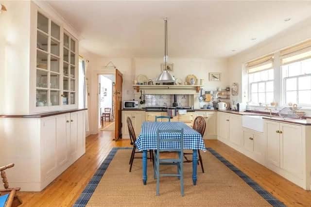 The traditional style kitchen has a dining table and Aga.