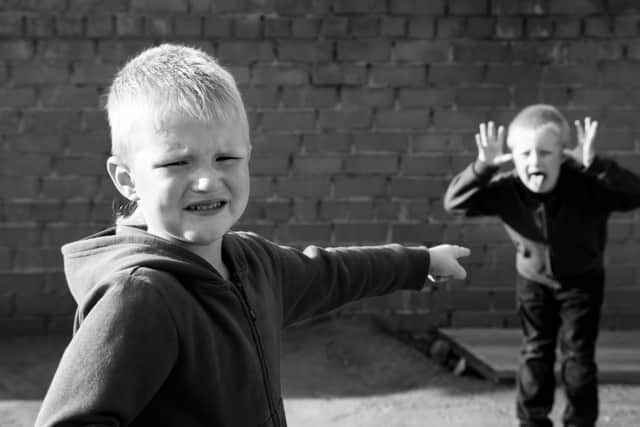 Telling on someone or grassing them up to the teacher for doing something they shouldnt.
