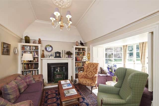 The sitting room has a wood burning stove and large bay windows.