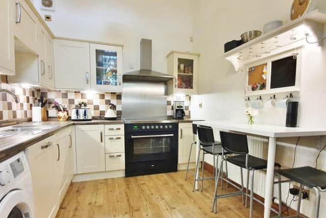 The kitchen is to the left of the living room and has its own stained-glass window.