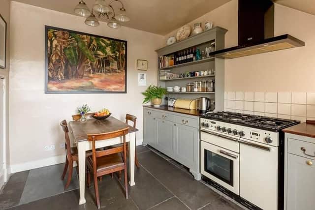 The traditional style kitchen has a range cooker and flagstone flooring.