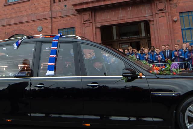 The Rangers squad join in the applause as the funeral cortege passes Ibrox.