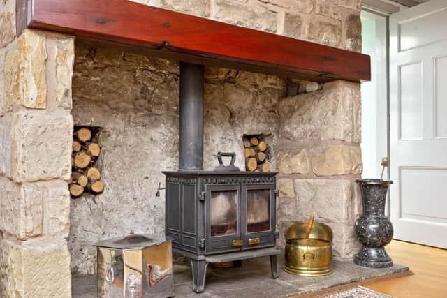 The exposed stone fireplace with wood burning stove have been preserved to maintain the propertys character and charm.
