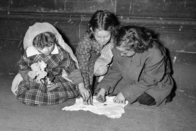 It was usual to 'do a turn' when out guising and sing a song or tell a joke at the houses that you called at. These children in Leith count their guising money back in 1951.